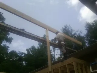 Carpenter setting a ridge beam over a new addition frame — Ice Dam Removal by Roofing Brothers in Sabinsville
