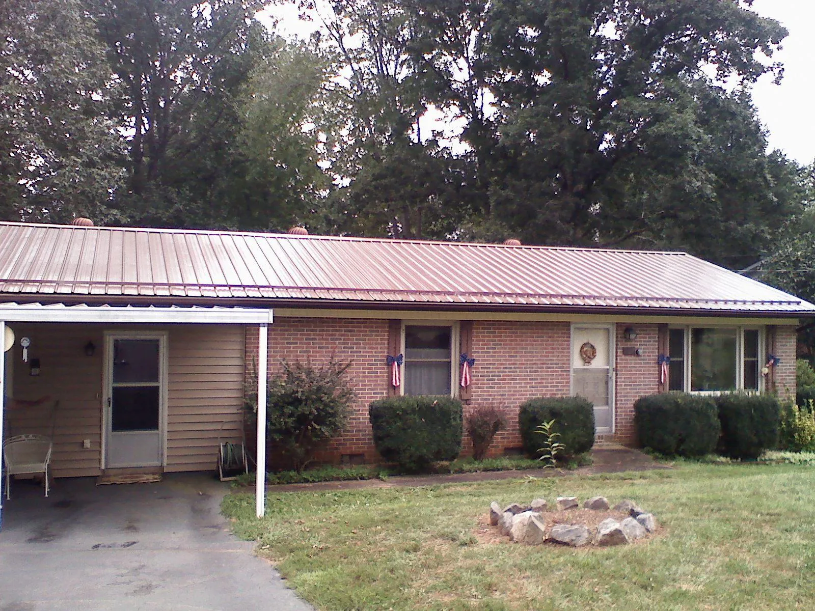 Bronze metal roof and carport on a brick ranch home — Roof Repair work by our crew in Sabinsville